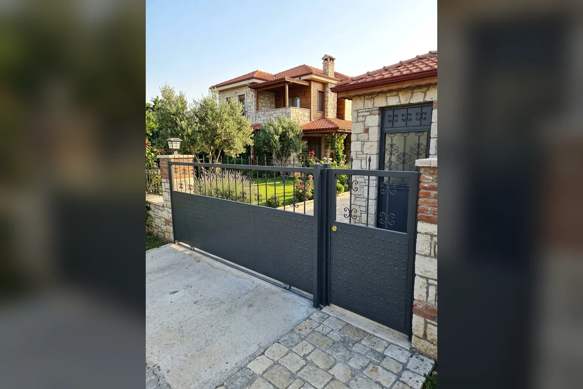 Taş villa önünde siyah sürgülü araç ve yaya kapısı